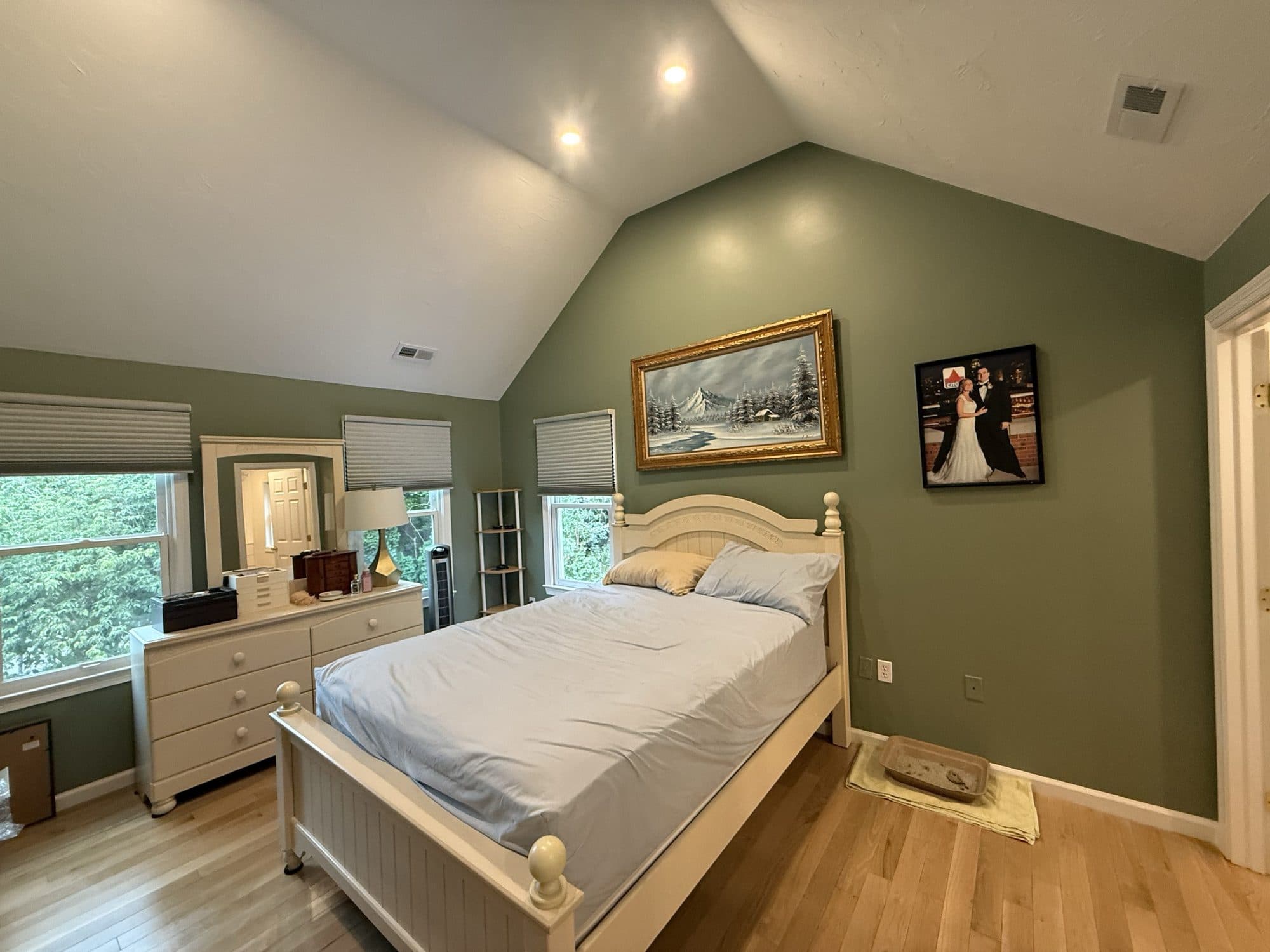 Bedroom with a soft green accent wall and white trim