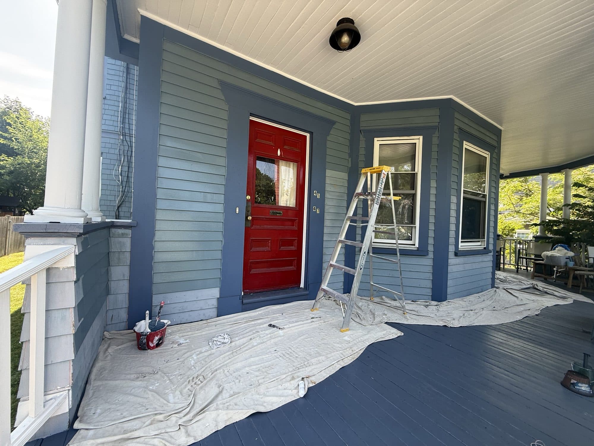 Blue clapboard porch with a bright red front door