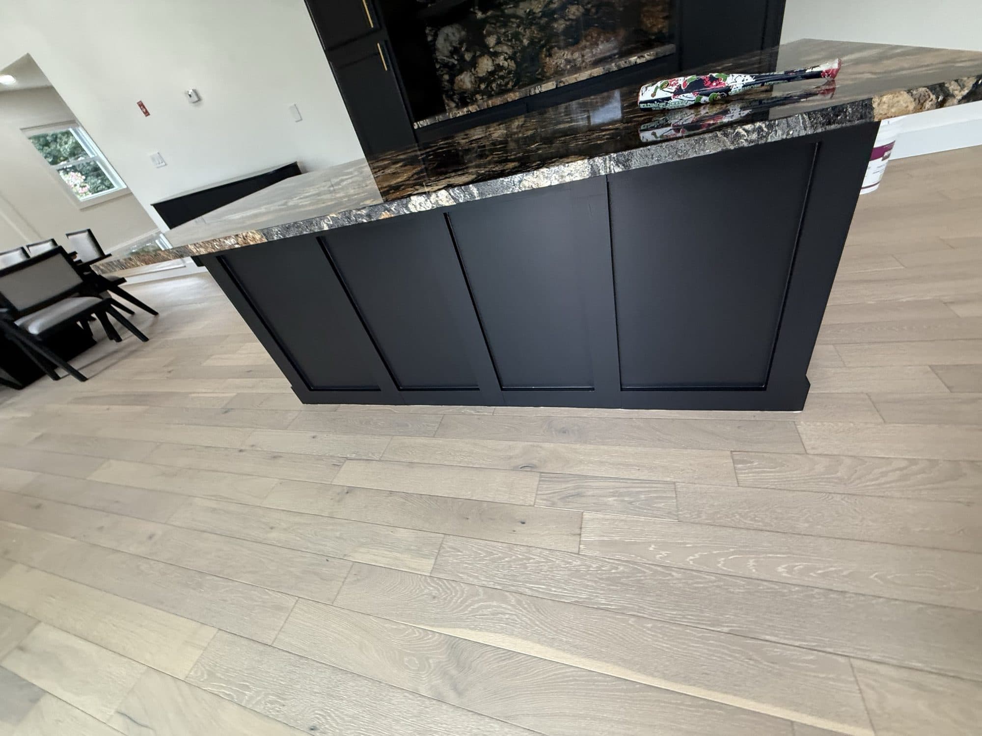 Kitchen island in deep charcoal with a stone waterfall counter
