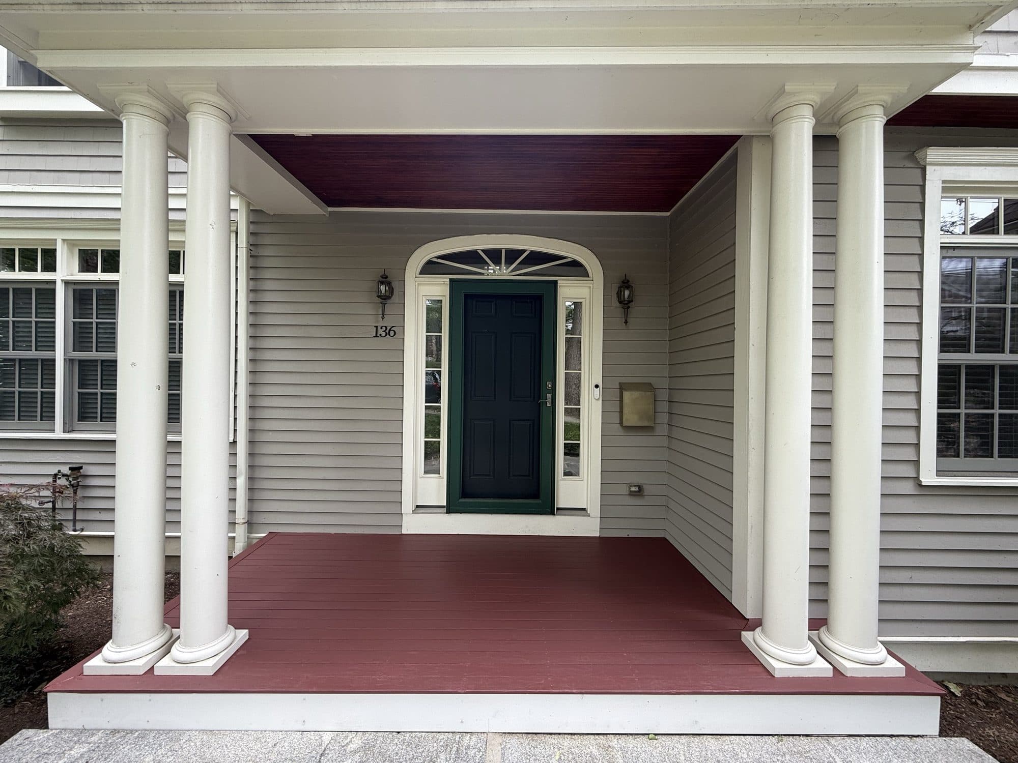 Front porch with white columns and a navy front door