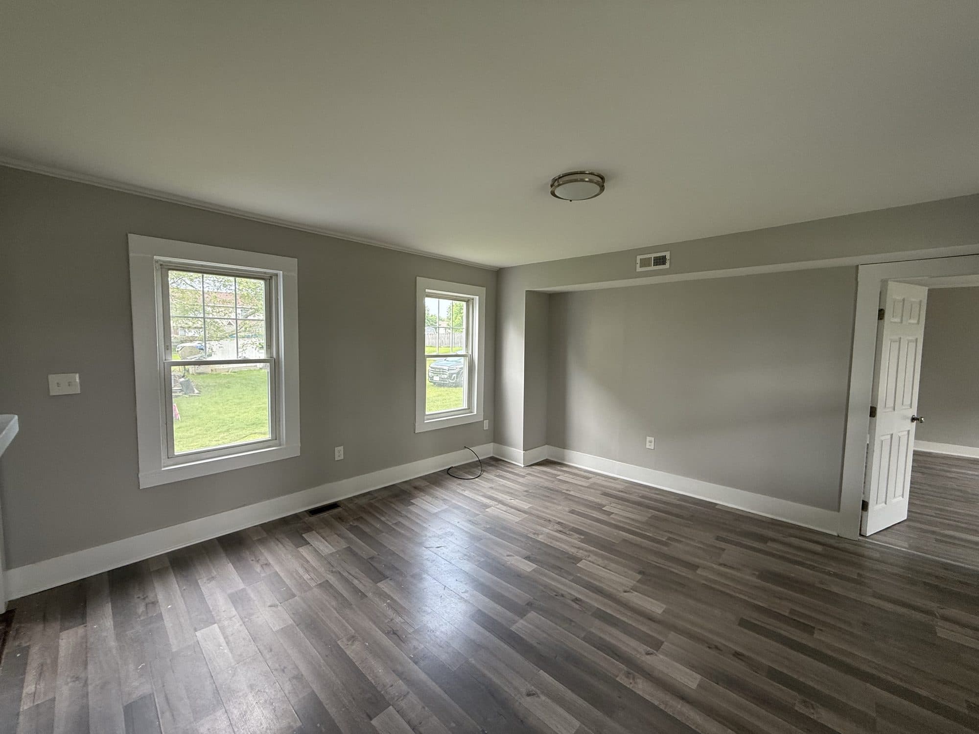 Open living space with grey walls and dark plank floors